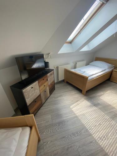 a attic room with two beds and a tv at Pension Lizzi in Vienna