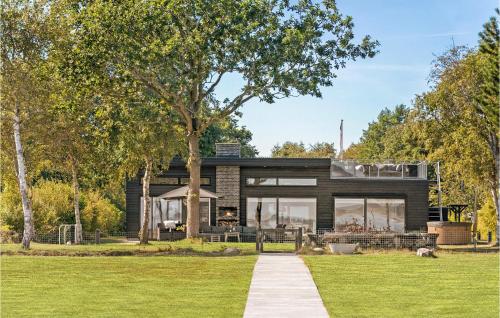 a black house with a tree in the yard at Awesome Home In Thyholm With Wifi in Thyholm