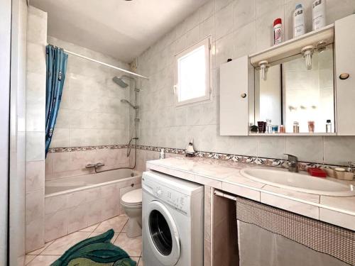 ein Badezimmer mit Waschmaschine und Waschbecken in der Unterkunft Maison Marina Pietra avec Jardin in Pietracorbara