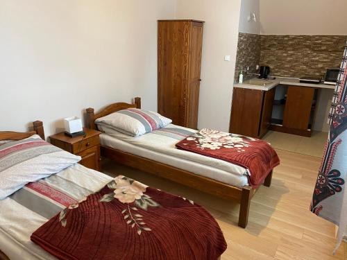 a hotel room with two beds and a kitchen at Domek pod lasem in Białka Tatrzanska