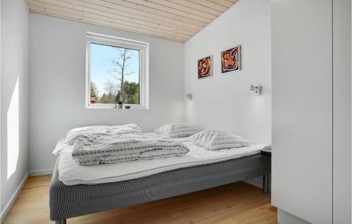 a bed in a white room with a window at 3 Bedroom Cozy Home In Ørsted in Ørsted