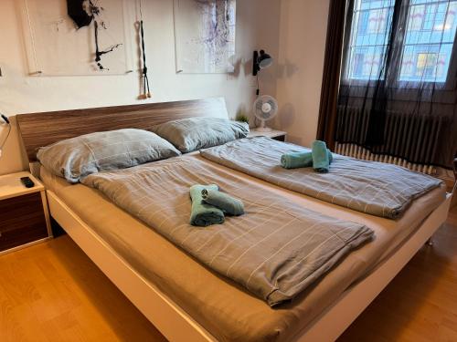 a large bed with two stuffed animals on it at Altstadt Gästehaus in Arbon