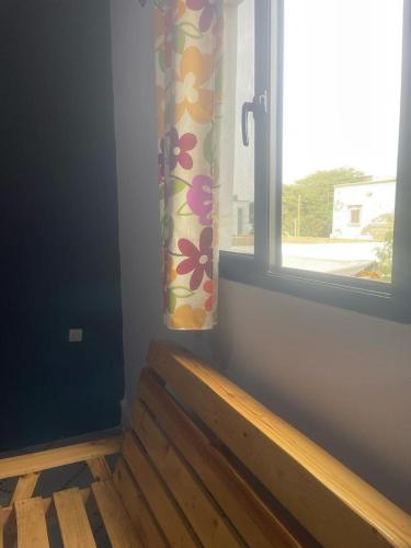 a room with a window with a wooden bench and a window curtain at Auberge Tunisien in Nouakchott