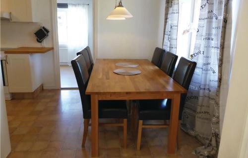 a wooden dining room table with black chairs at Gorgeous Home In Flen With Sauna in Flen