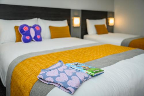 two beds in a hotel room with slippers on them at Newtown Park Hotel in Wexford