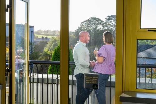 a man and a woman standing in front of a window at Newtown Park Hotel in Wexford