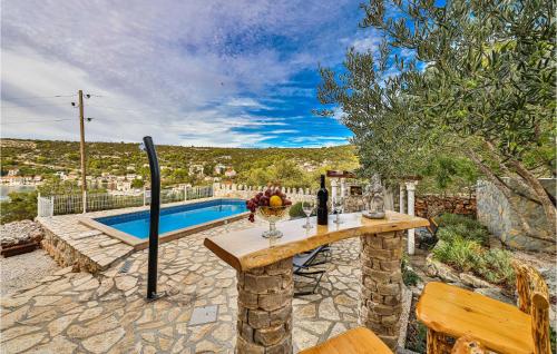 a patio with a table and a swimming pool at Two-Bedroom Holiday Home In Drvenik Veli in Veliki Drvenik