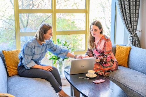 two women sitting around a table with a laptop at Newtown Park Hotel in Wexford