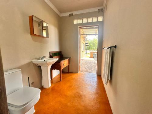a bathroom with a white toilet and a sink at Farm stay at Lavender Cottage on Haldon Estate in Bloemfontein