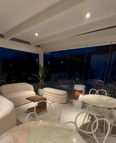 a living room with white furniture and a large window at infinity Castellabate b & b di Charme in Santa Maria di Castellabate