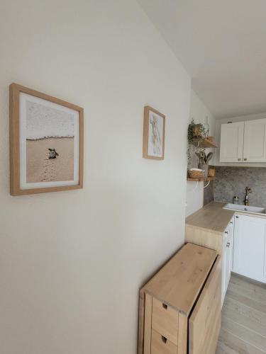 une cuisine avec des armoires blanches et une table en bois dans l'établissement Béréa - Clair de Plage, à Aresquies