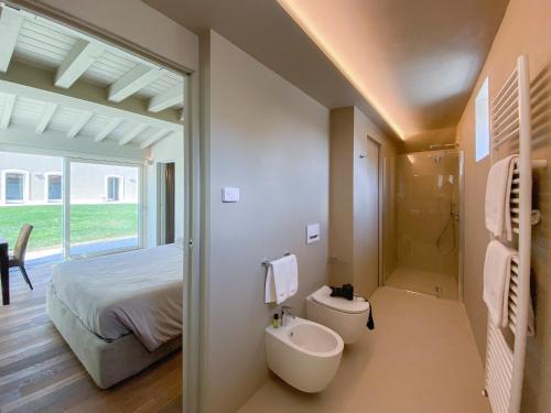une salle de bain avec un lavabo et des toilettes et un lit dans l'établissement Time to Relax - Lago di Garda - Adults only, à Ponti sul Mincio