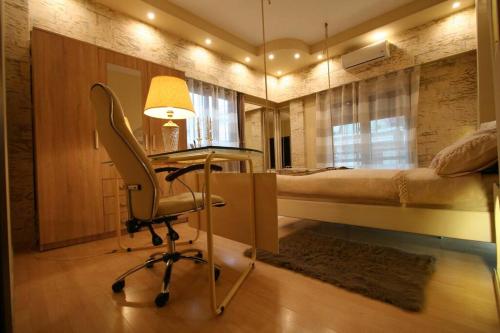 a bedroom with a desk and a bed and a chair at C i t y v i b e s Διαμέρισμα Α1 in Ioannina