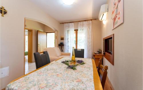 a dining room with a table and a living room at 2 Bedroom Amazing Home In Pridraga in Pridraga