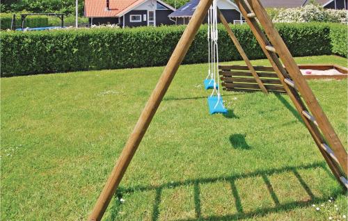a swing set in the grass in a yard at Holiday Home Pøt Strandby Juelsminde Q in Sønderby