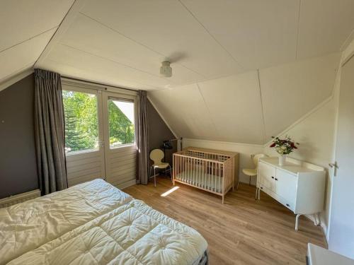 a bedroom with a bed and a crib in it at Familiehuis Zeegserduinen in Zeegse