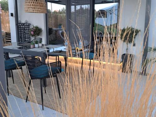 een tafel en stoelen op een terras met hoog gras bij Villa secrecy in Lixouri