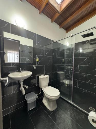 a bathroom with a toilet and a sink and a shower at Apartamento Laureles-Estadio-la70 a 15min Provenza in Robledo