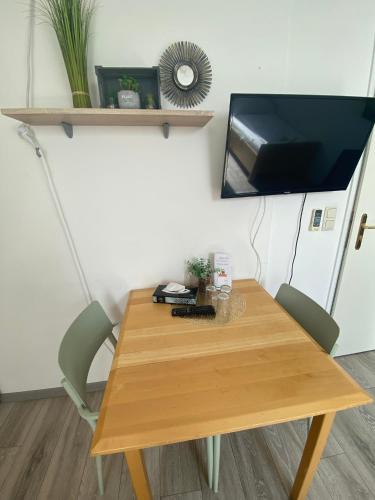 a wooden table with two chairs and a television on a wall at Pension Lizzi in Vienna