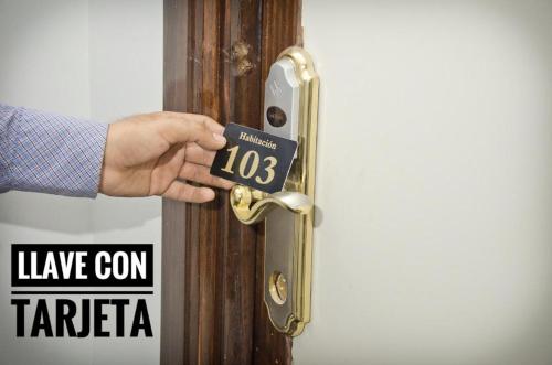a person holding a door with a sign on it at Le Prince Tacna in Tacna