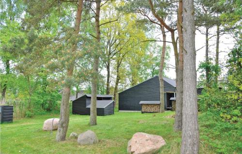 a black house in the middle of a yard with trees at Holiday Home Strandskadevej Ørsted Xi in Kare