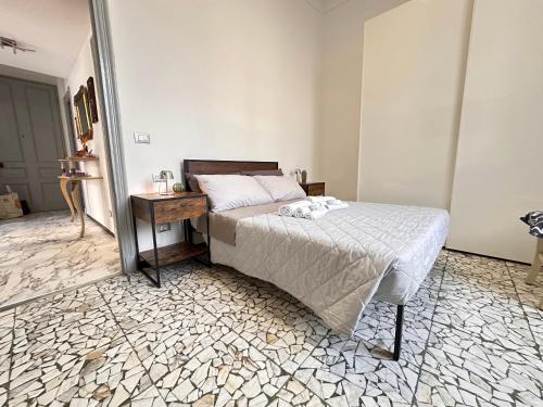 a bedroom with a bed and a table in it at SANREMO Mare e Relax - Affittasi Alloggio della Piazza con Aria condizionata, Balcone e ampia disponibilità di parcheggi liberi in Sanremo