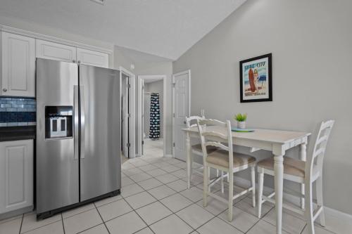 a kitchen with a stainless steel refrigerator and a table at Parrotise in Surf City
