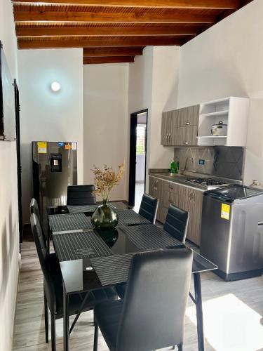 a dining room with a table and chairs and a kitchen at Apartamento Laureles-Estadio-la70 a 15min Provenza in Robledo