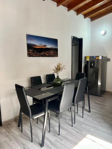 a black dining room table with chairs and a painting on the wall at Apartamento Laureles-Estadio-la70 a 15min Provenza in Robledo