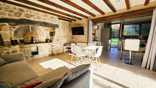 a living room with a couch and a stone fireplace at Gîte de France Le fournil 3 épis - Gîte de France 2 personnes MAE-6664 in Marcillac-la-Croisille