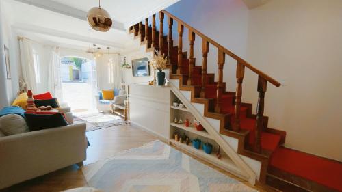 a living room with a staircase and a couch at Pousada Geada de Campos in Campos do Jordão