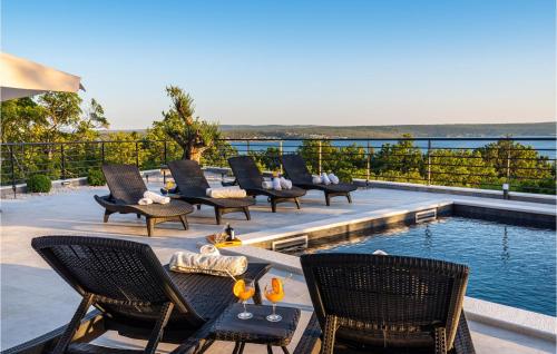 a group of chairs sitting on a patio next to a pool at Villa Hill in Maslenica
