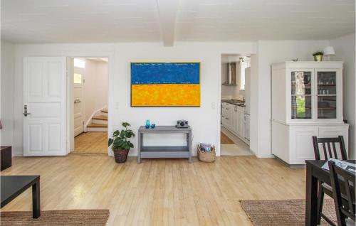 a living room with a table and a painting on the wall at Fyrassistentens in Kolby Kås