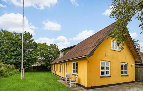 a yellow house with a brown roof at Nice Apartment In Bindslev With Wifi in Bindslev