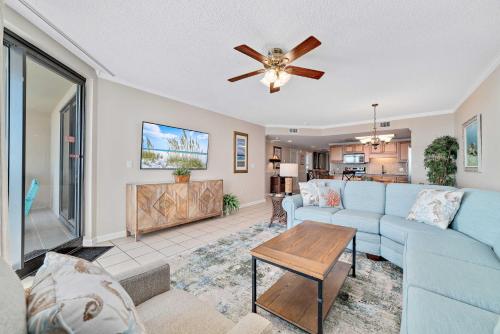 a living room with a blue couch and a ceiling fan at Phoenix 10 Unit 1514 in Orange Beach