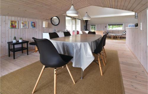 a dining room and living room with a table and chairs at Three-Bedroom Holiday Home In Otterup in Otterup