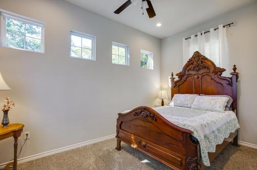 a bedroom with a large wooden bed and windows at Pet-Friendly Tomball Home Walk to Main Street! in Tomball