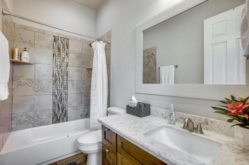 a bathroom with a sink and a toilet and a mirror at Pet-Friendly Tomball Home Walk to Main Street! in Tomball