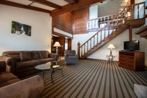 a living room with a couch and a tv at Sunburst Condominiums in Steamboat Springs