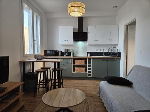un salon avec un canapé et une cuisine dans l'établissement Le Miquel-Appartement Béziers Centre, à Béziers