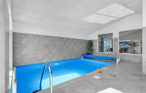 a large swimming pool in a white room with a blue tub at Lovely Home In Thisted With Sauna in Thisted