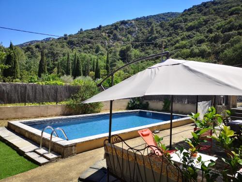 - un parasol blanc à côté de la piscine dans l'établissement Au goût du miel. Luberon-Provence., à Maubec