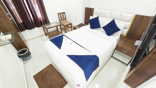 a bedroom with a large bed with blue pillows at Hotel SkyLand in Warangal