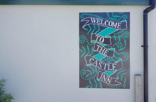 a welcome to the castle inn sign on a wall at Castle Inn in Newport