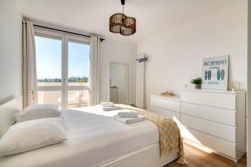 une chambre blanche avec un grand lit et une fenêtre dans l'établissement Appartement I Confort et Lumineux I 2 min du métro, à Toulouse