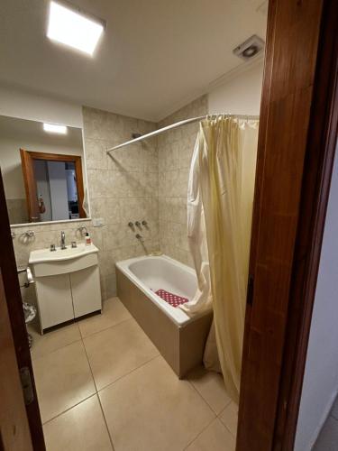 a bathroom with a bath tub and a sink at Departamento en planta baja in Necochea