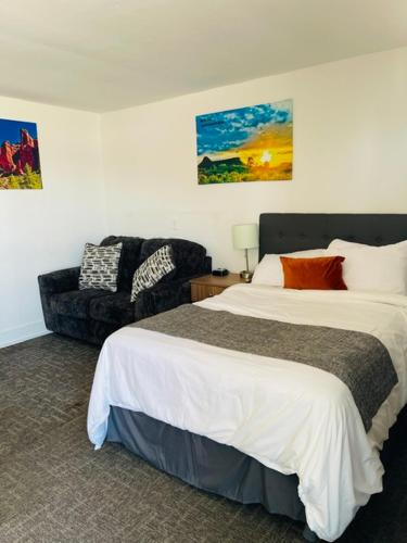 a hotel room with a bed and a chair at Blue Sage Inn & Suites in Blanding