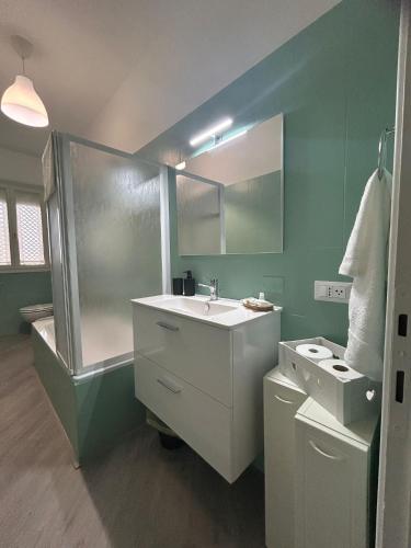 a green bathroom with a sink and a shower at SEA&SUN House in Marinella di Sarzana