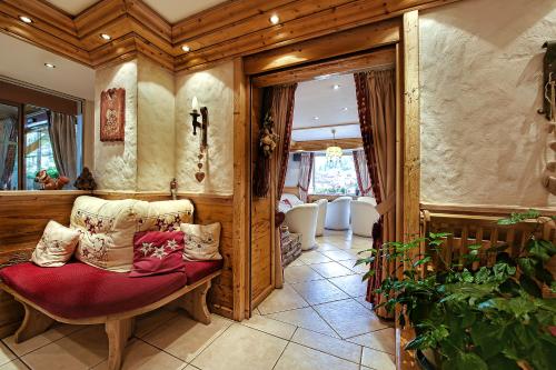 uma sala de estar com uma cadeira e uma janela em Hotel les Sapins em La Clusaz