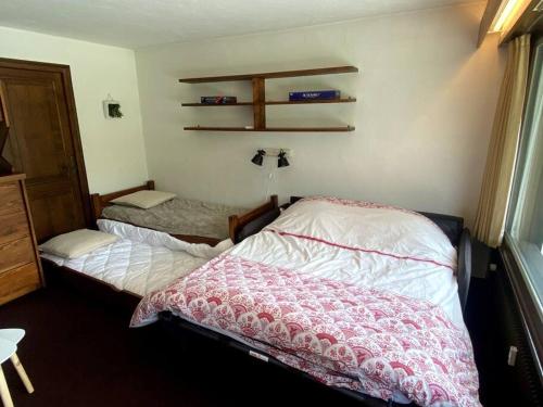 - une chambre avec un lit et une étagère sur le mur dans l'établissement Grand Studio à 300m du pied des pistes,, à Megève